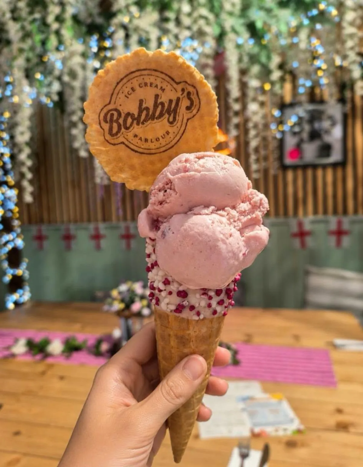 A strawberry Snugburys cone with sprinkles inside the flower-filled tea room